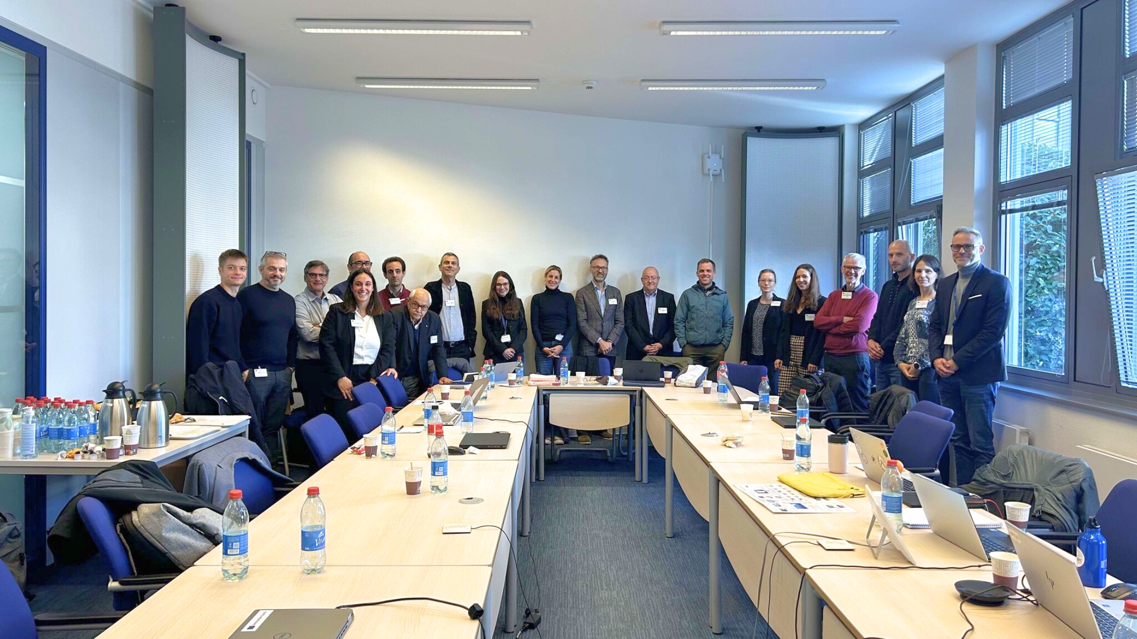 Group of people standing in a large room.