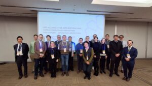 Group photo of speakers and organisers at an HPC event, standing in front of a projection screen displaying “HPC Alliance for Applications and Supercomputing Innovation: The Europe–Japan Collaboration".