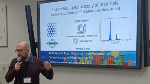 Speaker presenting a lecture on theoretical spectroscopy of materials and optical absorption by first-principles simulations, with slides showing graphs and institutional affiliations including CNR Nano and HANAMI.