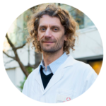 Man with brown hair with a white lab coat.