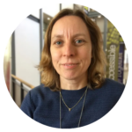 Woman with light brown hair with dark blue shirt.