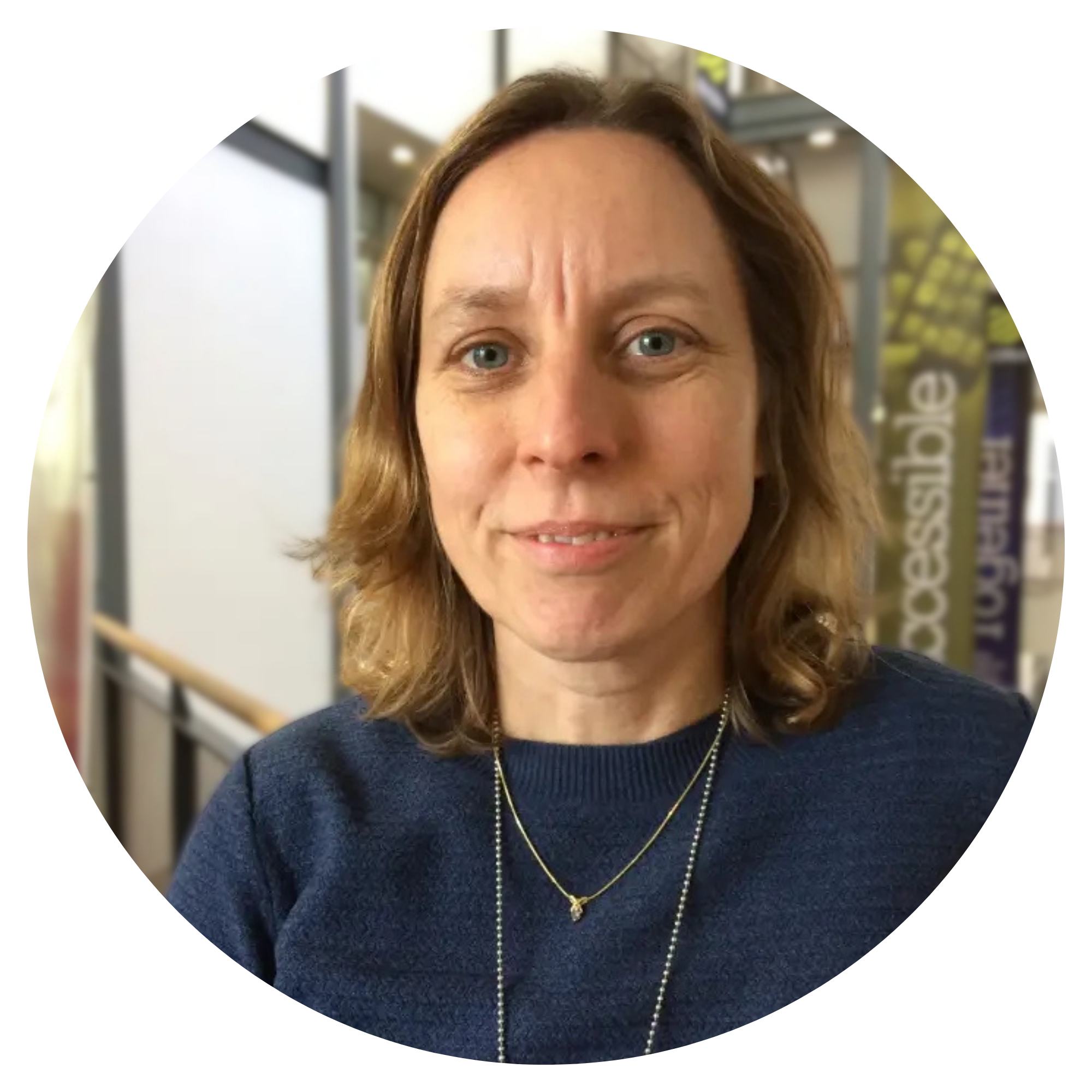 Woman with light brown hair with dark blue shirt.